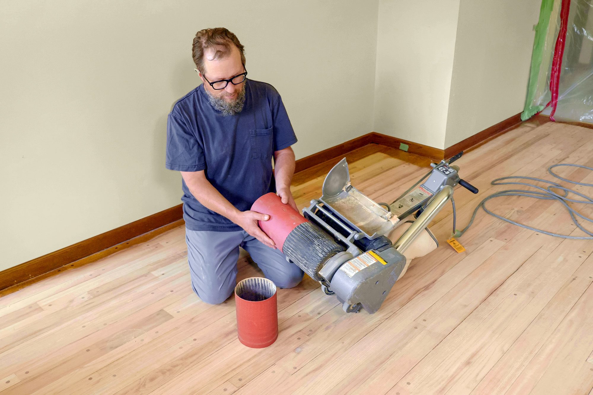 Man changing Sandpaper of Drum Sander