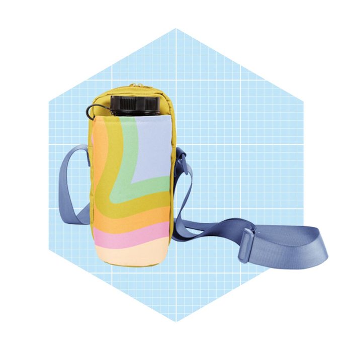 A colorful carrying bag holds a water bottle, featuring a shoulder strap, set against a light blue, grid-patterned background.