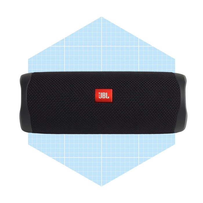 A black portable speaker rests against a light blue geometric background, designed for music playback. The speaker features a prominent red logo.