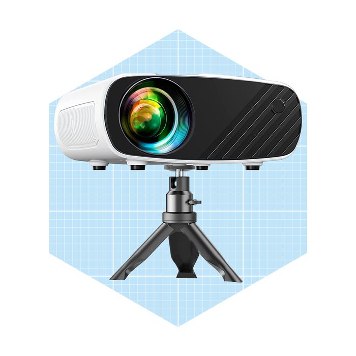 A projector sits on a tripod, projecting vibrant colors, set against a light blue grid background.