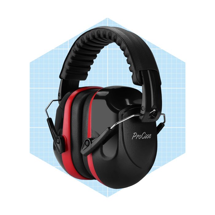 Black and red earmuffs rest on a light blue geometric background, designed for noise reduction, with a cushioned headband for comfort.