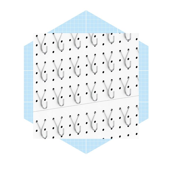 A white pegboard displays multiple metal hooks arranged in rows, designed for organizing tools or items, set against a blue grid-patterned background.
