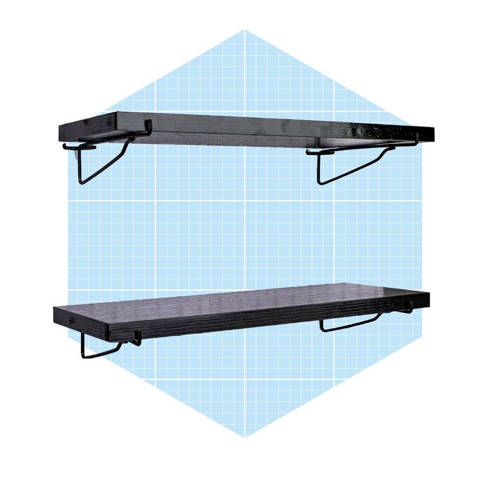 Two black floating shelves are mounted on wall brackets, positioned against a light blue grid-patterned background, designed for storage or display.