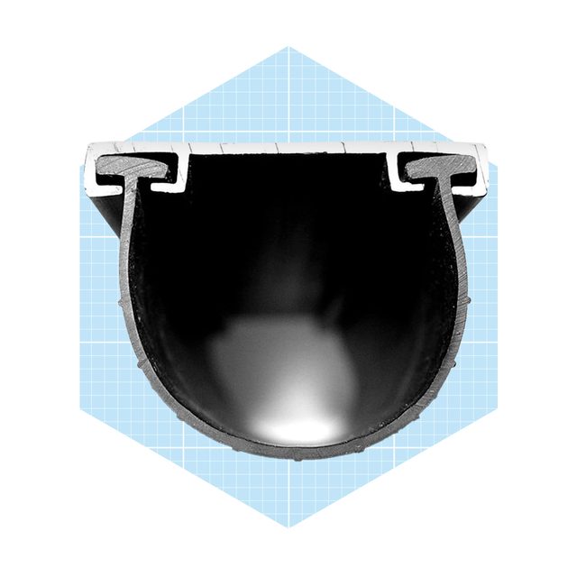 A cross-section of a black cylindrical object lays flat, showcasing its empty interior surface. It is set against a light blue grid background.