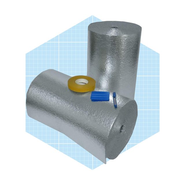 Two rolls of reflective insulation are lying on a light blue grid background, accompanied by yellow tape and two blue tools.