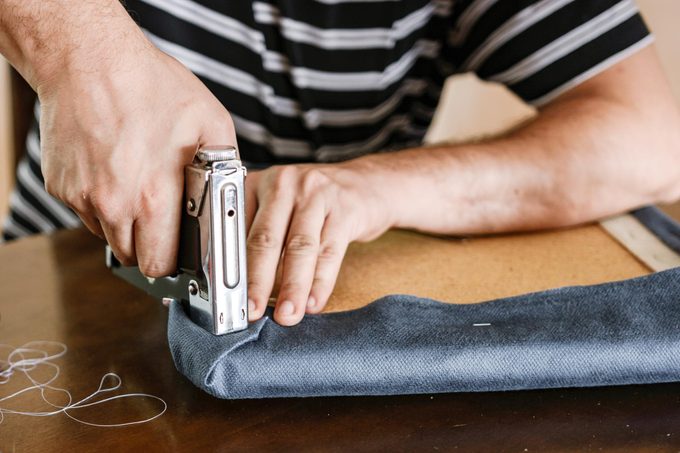 Man upholstering chair at home