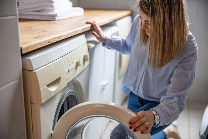 Woman Taking Clothes Out From Washing Machine