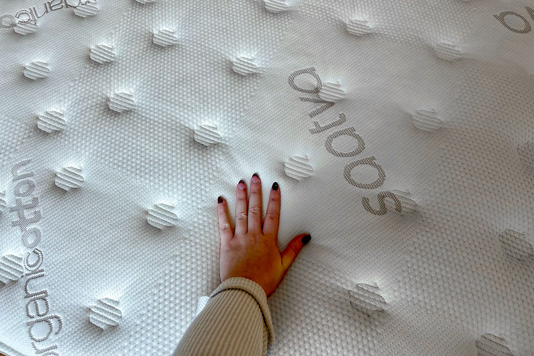 Woman's hand on mattress 