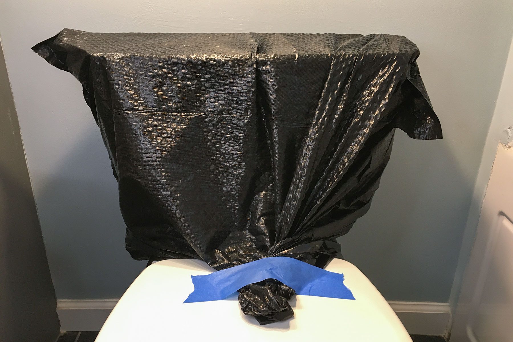 Trash bag covering the top of toilet