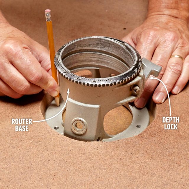 A person is using a pencil to fix lamination in the wood.