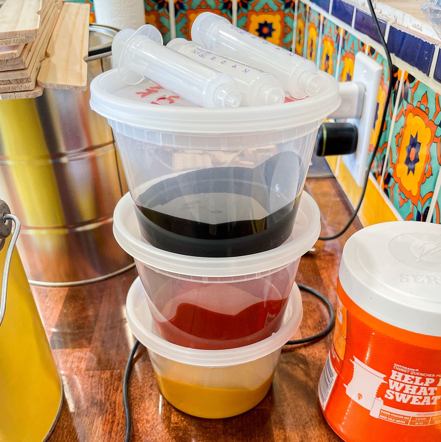 A Stack Of 3 Plastic Containers Each Half Filled With Paint