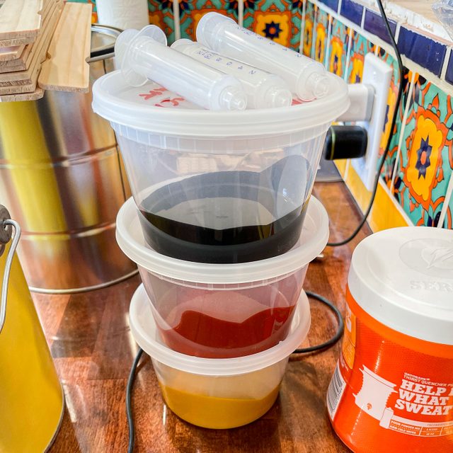 A Stack Of 3 Plastic Containers Each Half Filled With Paint