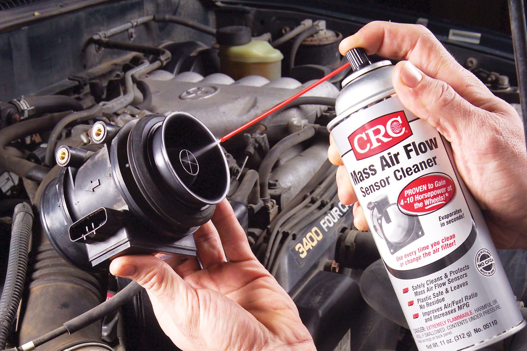 A person cleaning the Mass Air Flow Sensor