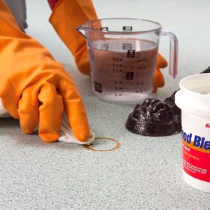 A Person Removing Tough Stains from Vinyl Flooring