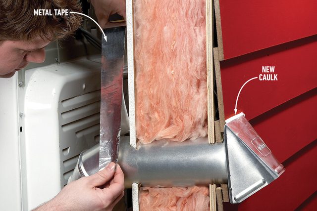 A person applies metal tape to a duct pipe protruding through an insulated wall with pink fiberglass insulation. A label points to an area of shiny, newly applied caulk on the right side of the pipe. The background wall is red.