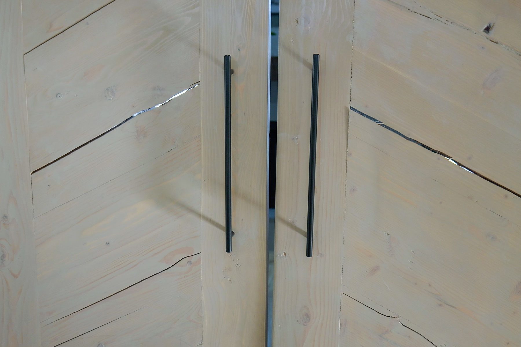 A wooden door with black handles