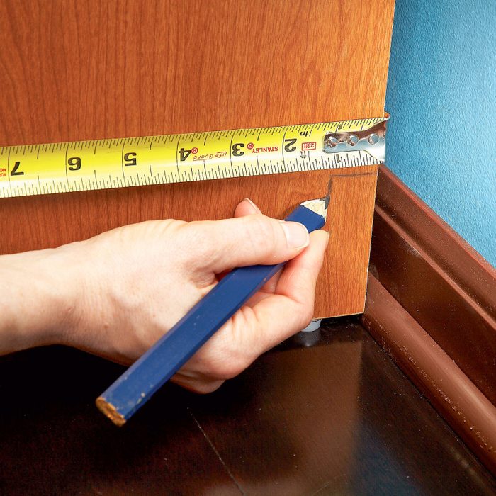 measuring with a tape measure and making a mark with a pencil