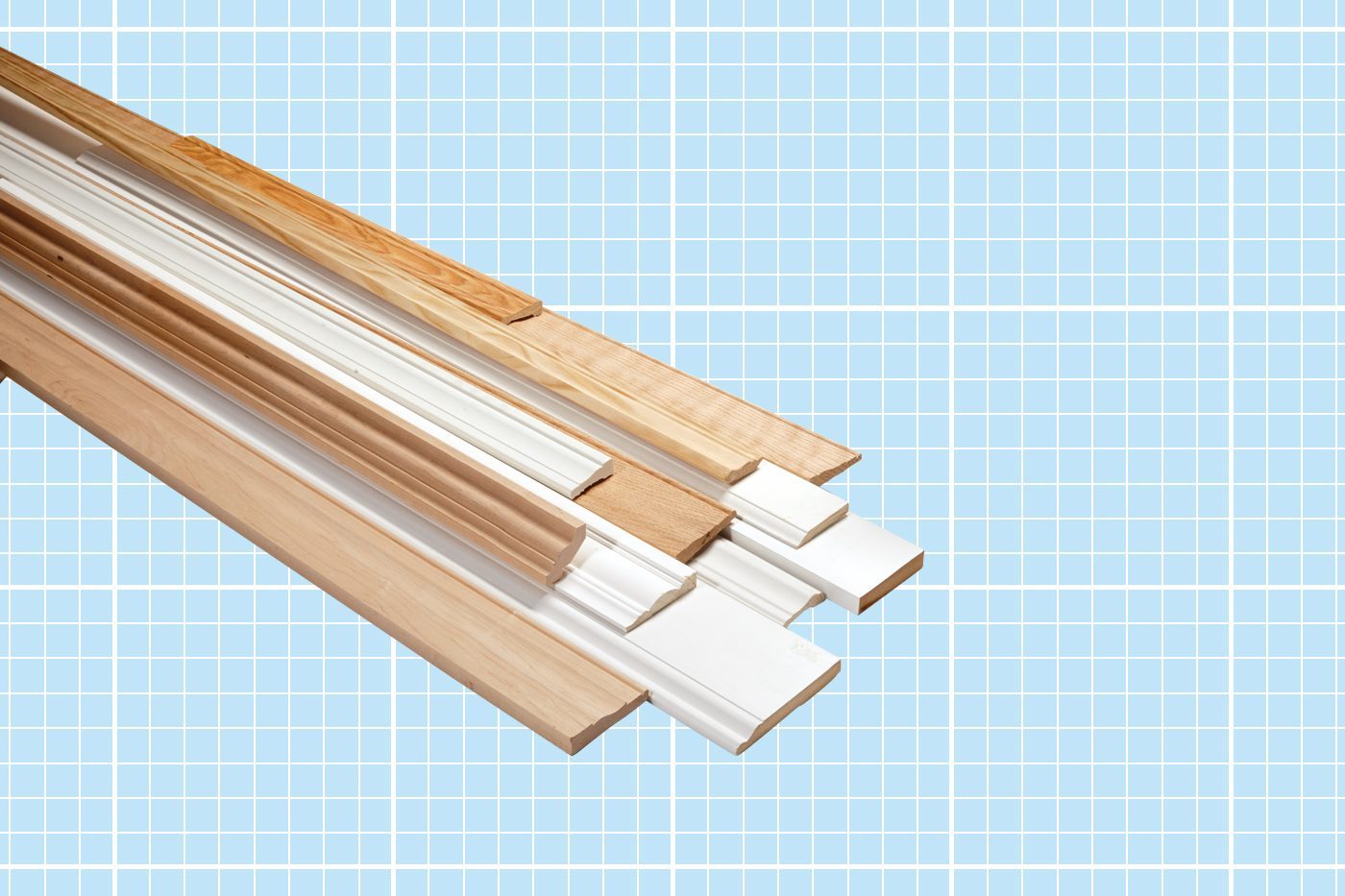 A collection of various types of wooden trim pieces, some painted white and others in natural wood color, displayed on a blueprint-style background. The trims are arranged at different angles, showcasing their profiles and designs.