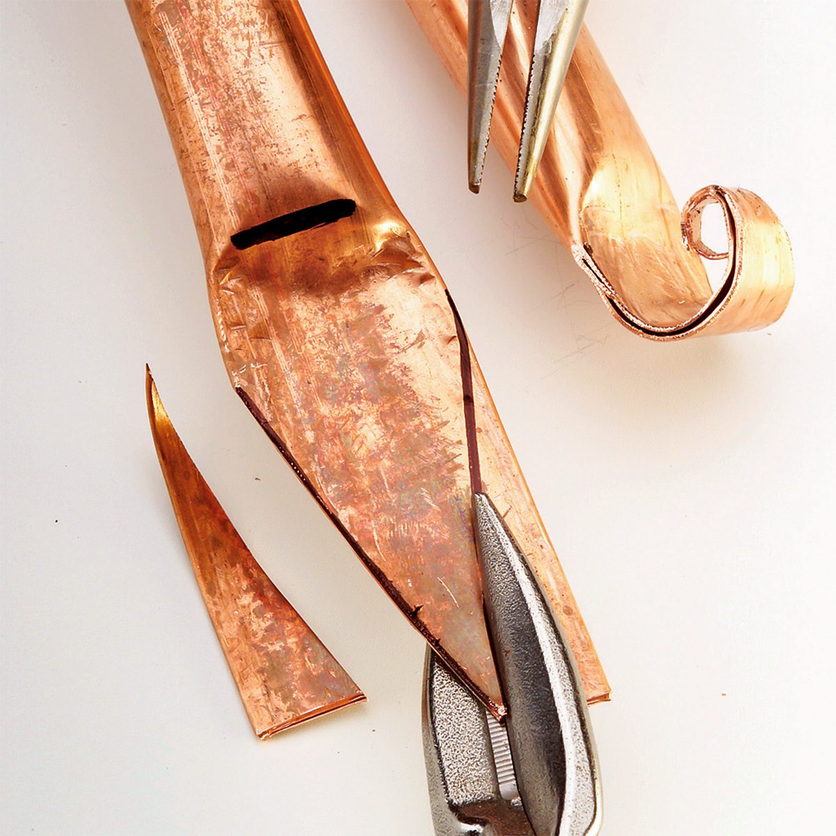 Decorative ends of copper tubes are being cut.