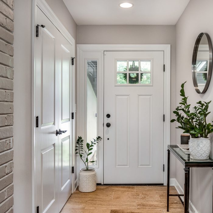 A cozy entryway with brown walls and a white front door