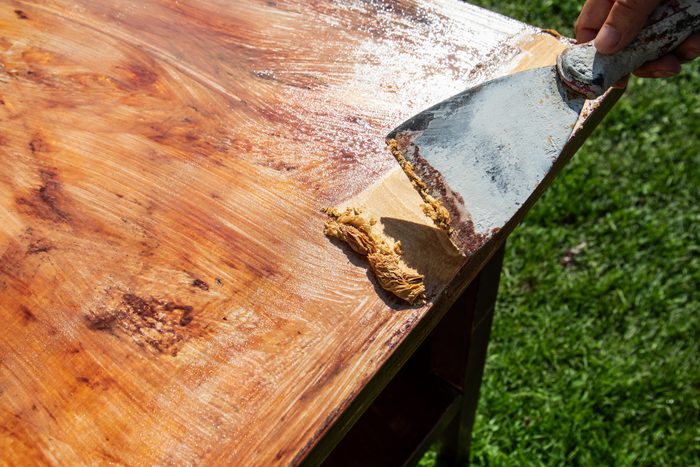 Scraped paint removed with a trowel, renovation of wood surface. Outdoor space