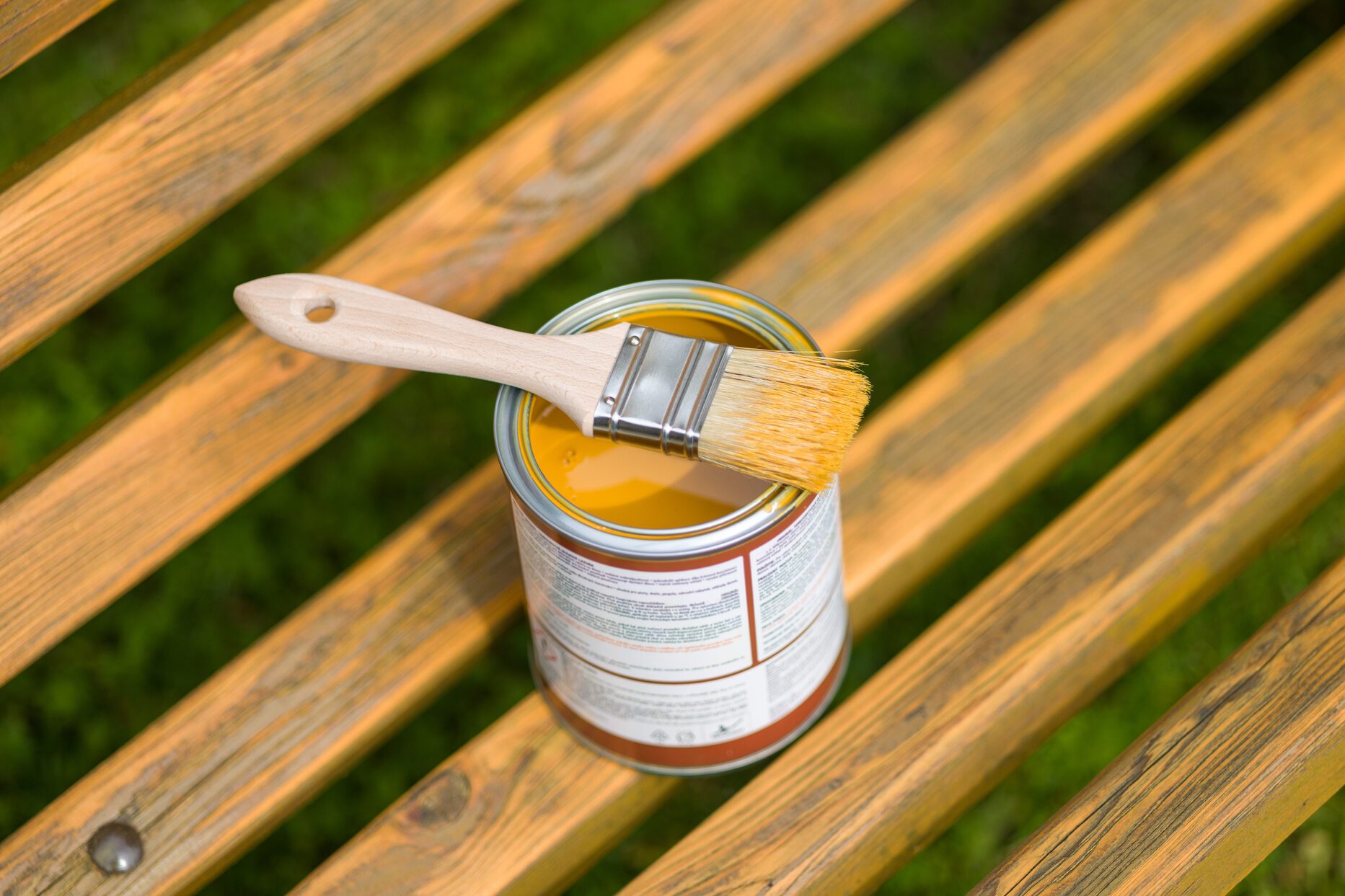 Paint Brush and Can on a Wooden Bench Outdoors