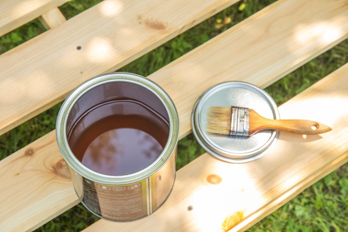 Image of paint brush on the opened can with primer on the wooden table. painting and renovation repairing concept