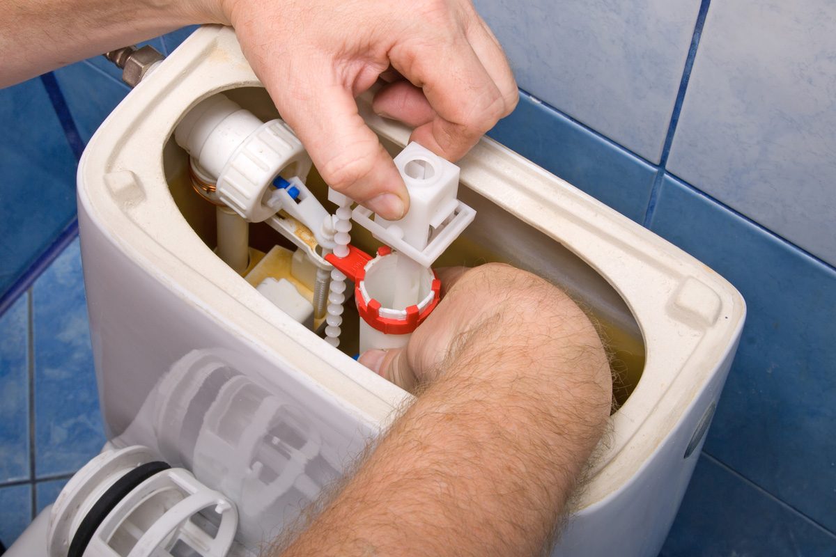 person fixing toilet