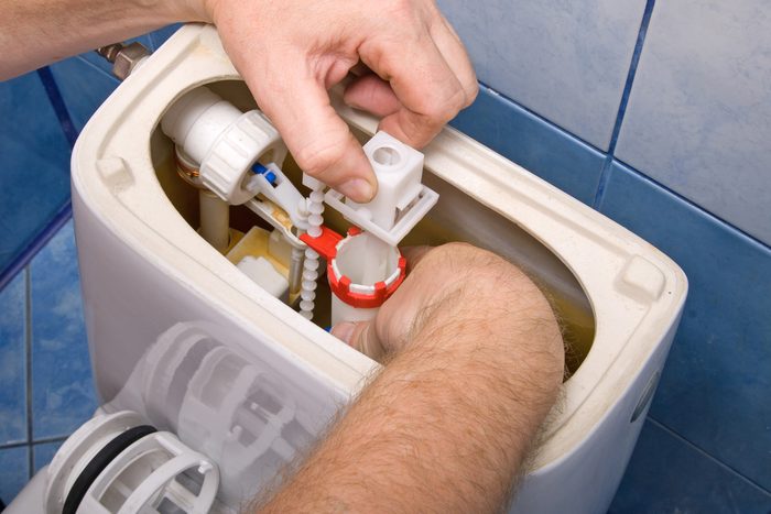 person fixing toilet
