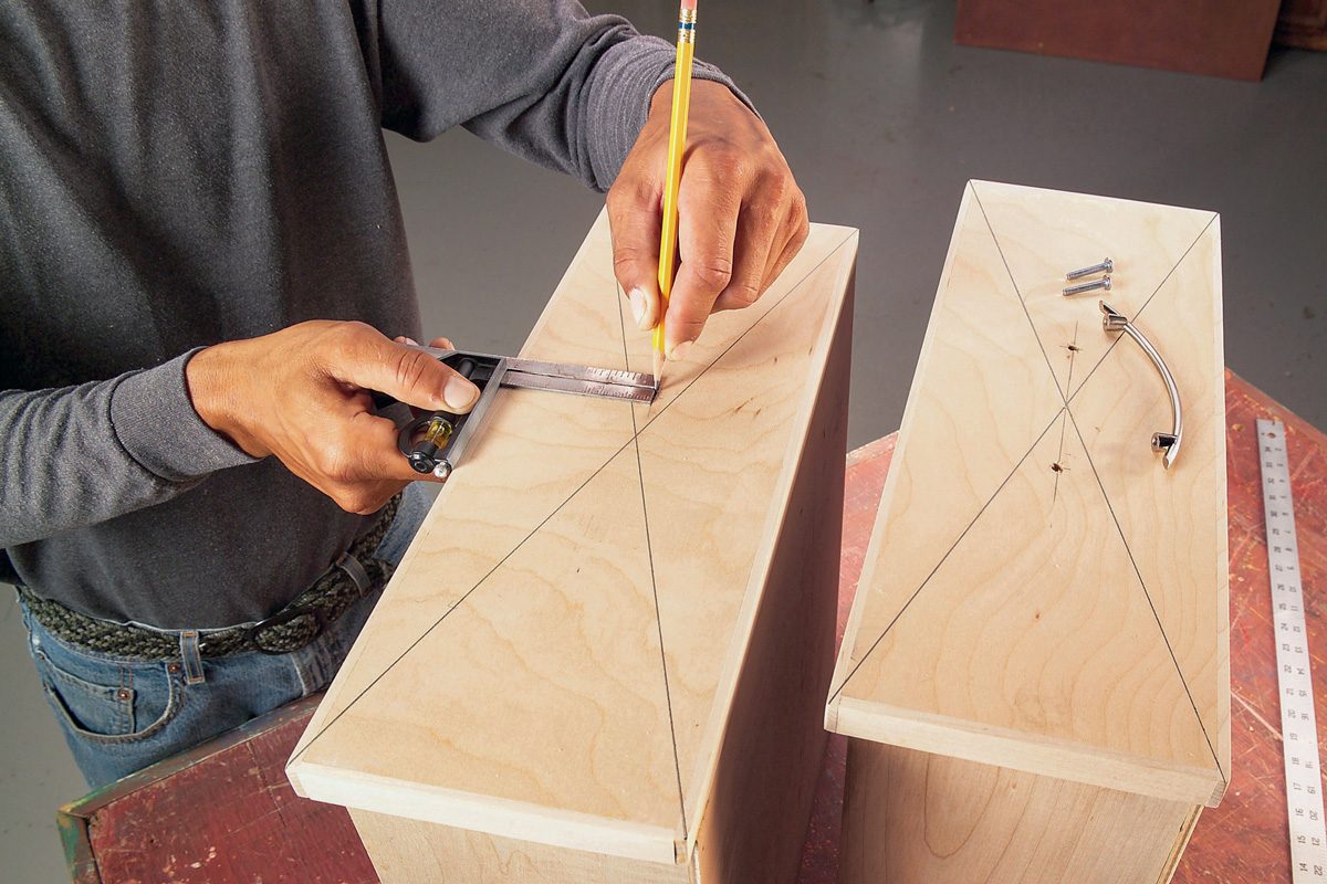 man marking drawers with pencil for drilling