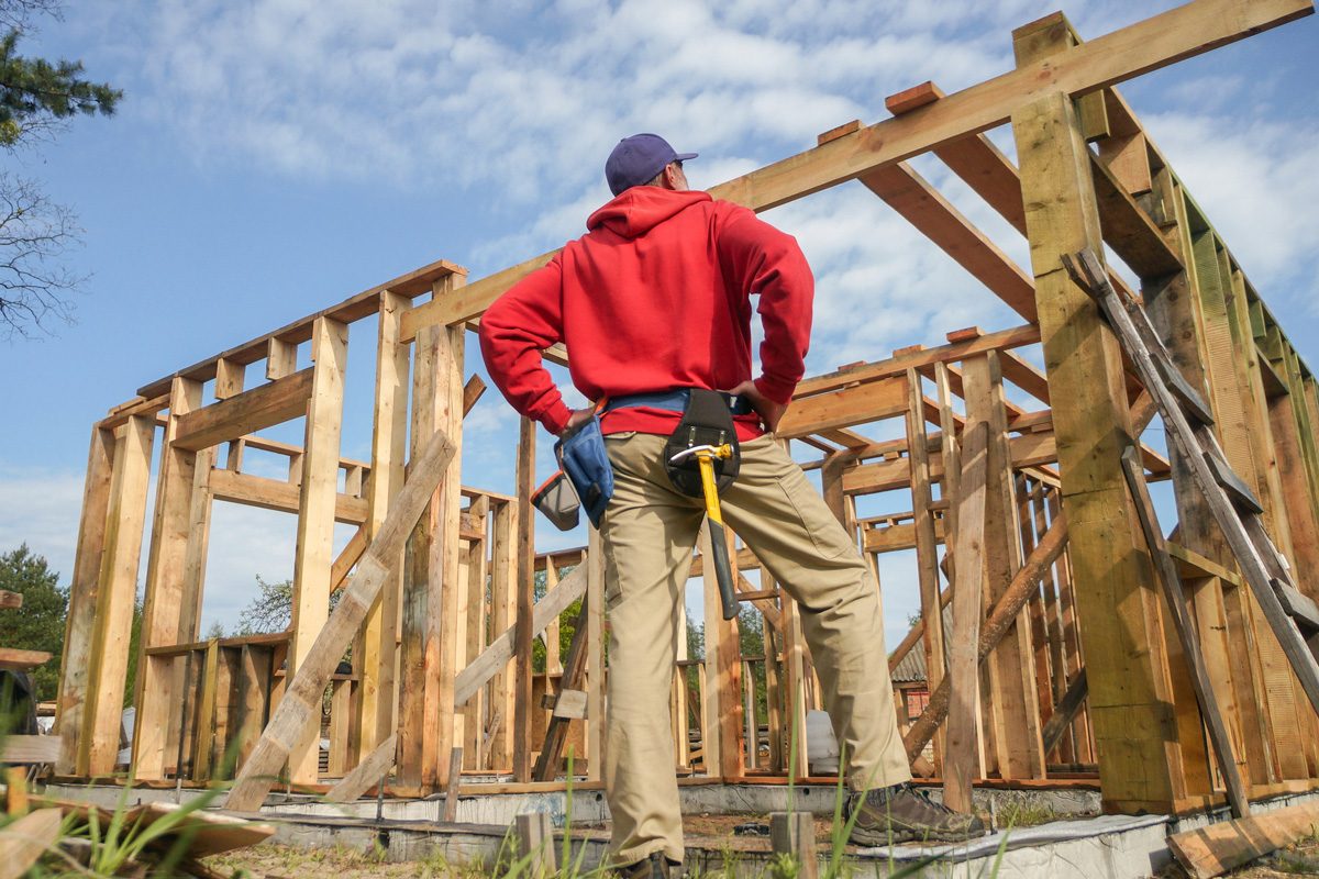 carpenter working on roof structure at construction site