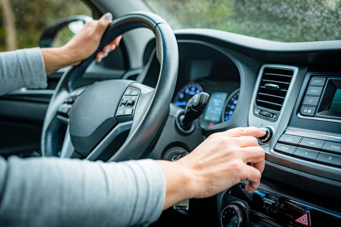 Adjusting Car Stereo Button While Driving In A Rainy Day