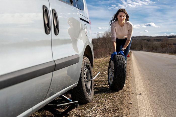 woman changing flat tire
