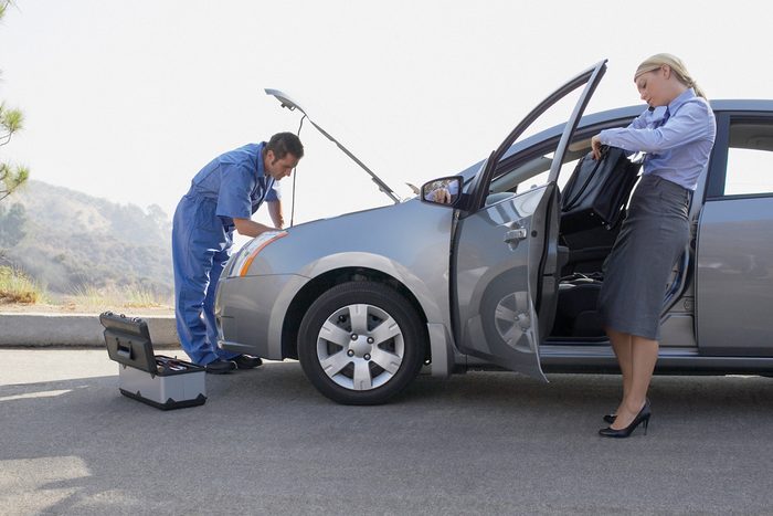 woman waiting for mechanic to fix car