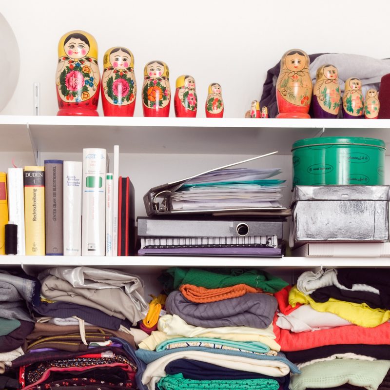 clothes, books and other belongings on shelf
