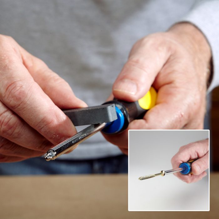 Close-up of hands holding a blue tool and a metal object in one hand, with a black plier-like tool in the other. Inset shows a side view of the blue tool with a metal piece. Background is blurred.
