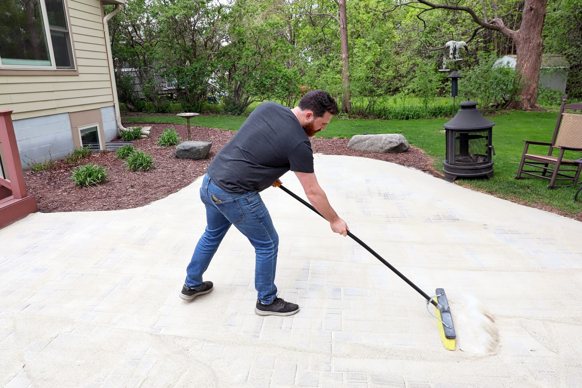 Man using Stabilizing Sealant on patio pavers