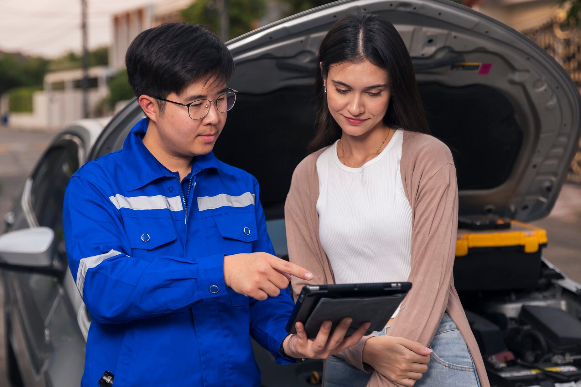 Insurance agent explaining car damage or breakdown to women customer