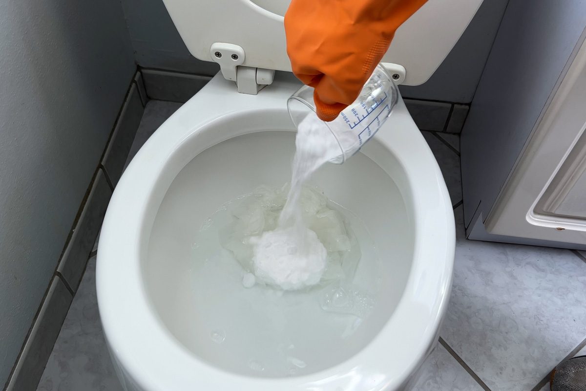 pouring baking soda into toilet