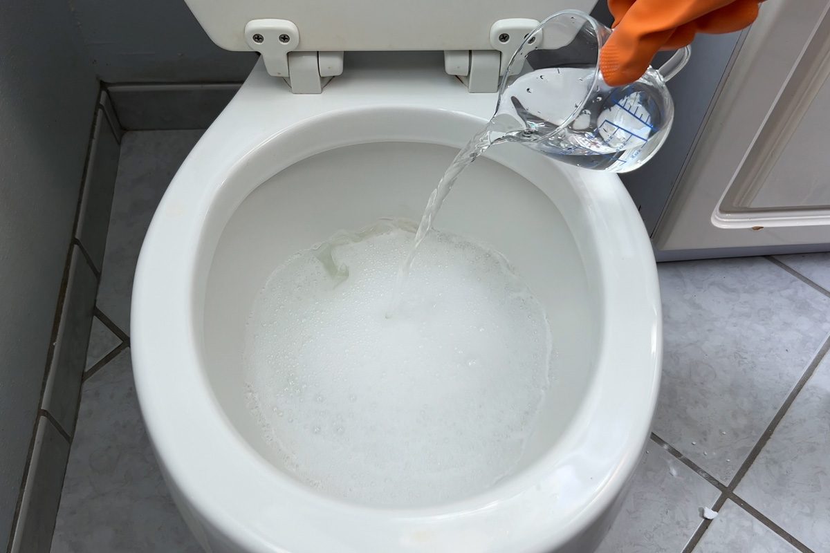 poring vinegar into toilet bowl