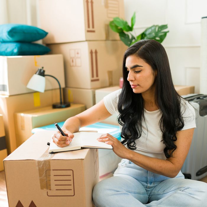 woman making a list surrounded by boxes