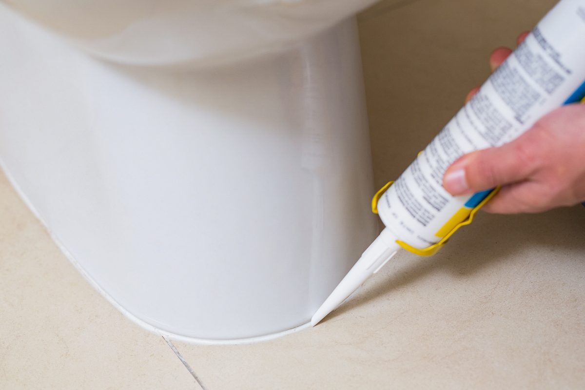 fixing toilet in a washroom with silicone cartridge