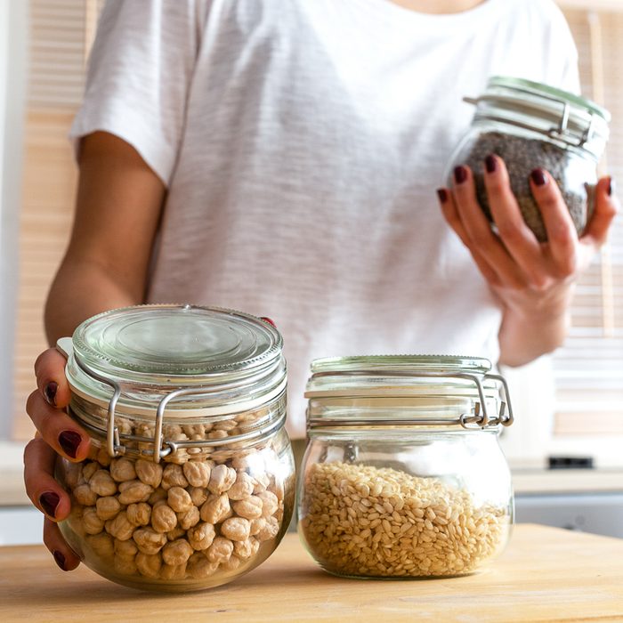 woman storing dry goods in jars