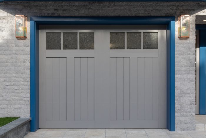 Exterior shot of a one car garage door with blue trim