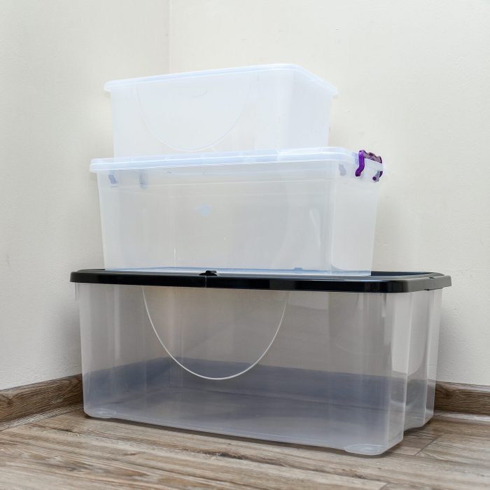 Empty plastic storage boxes stacked on the floor of the room