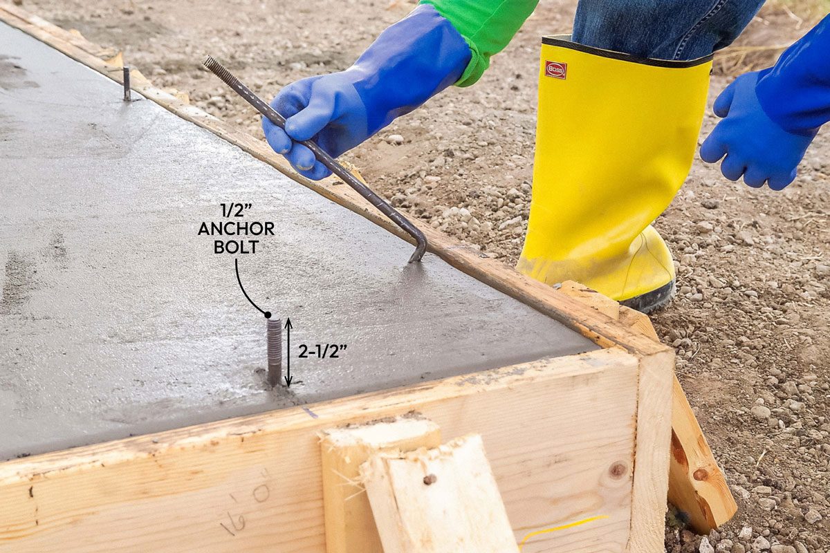 Close shot; Step 9 Set the Anchor Bolts; Press 1/2-inch anchor bolts into the concrete before it hardens; Place bolts one foot from corners and every six feet; Place bolts six inches from the sides of door openings; Leave about 2-1/2 inch of the bolts exposed;