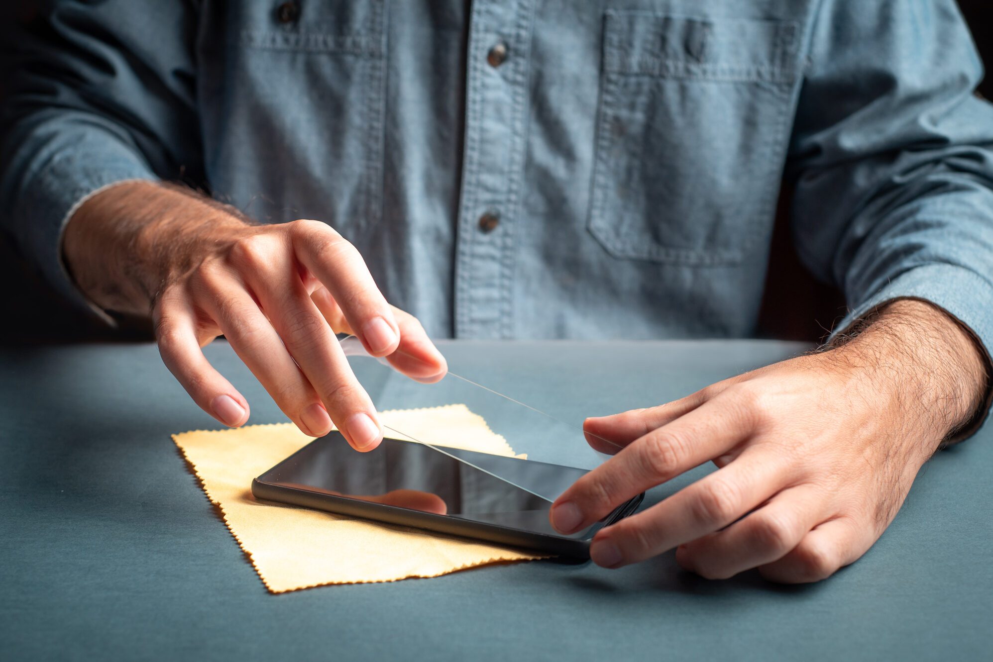 Man applying scratch resistant protective glass to smart phone screen close up
