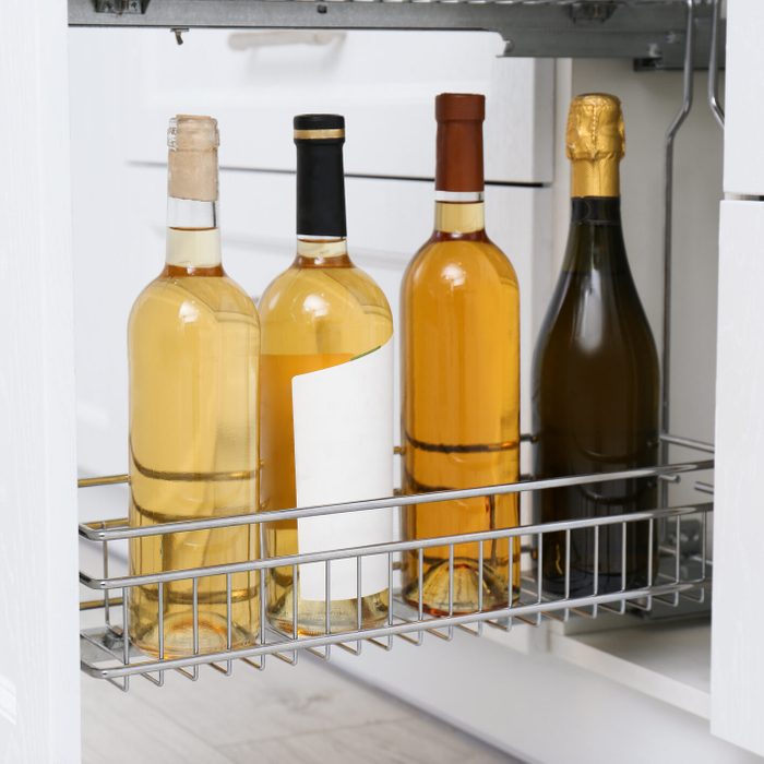 Open drawer with wine bottles in kitchen