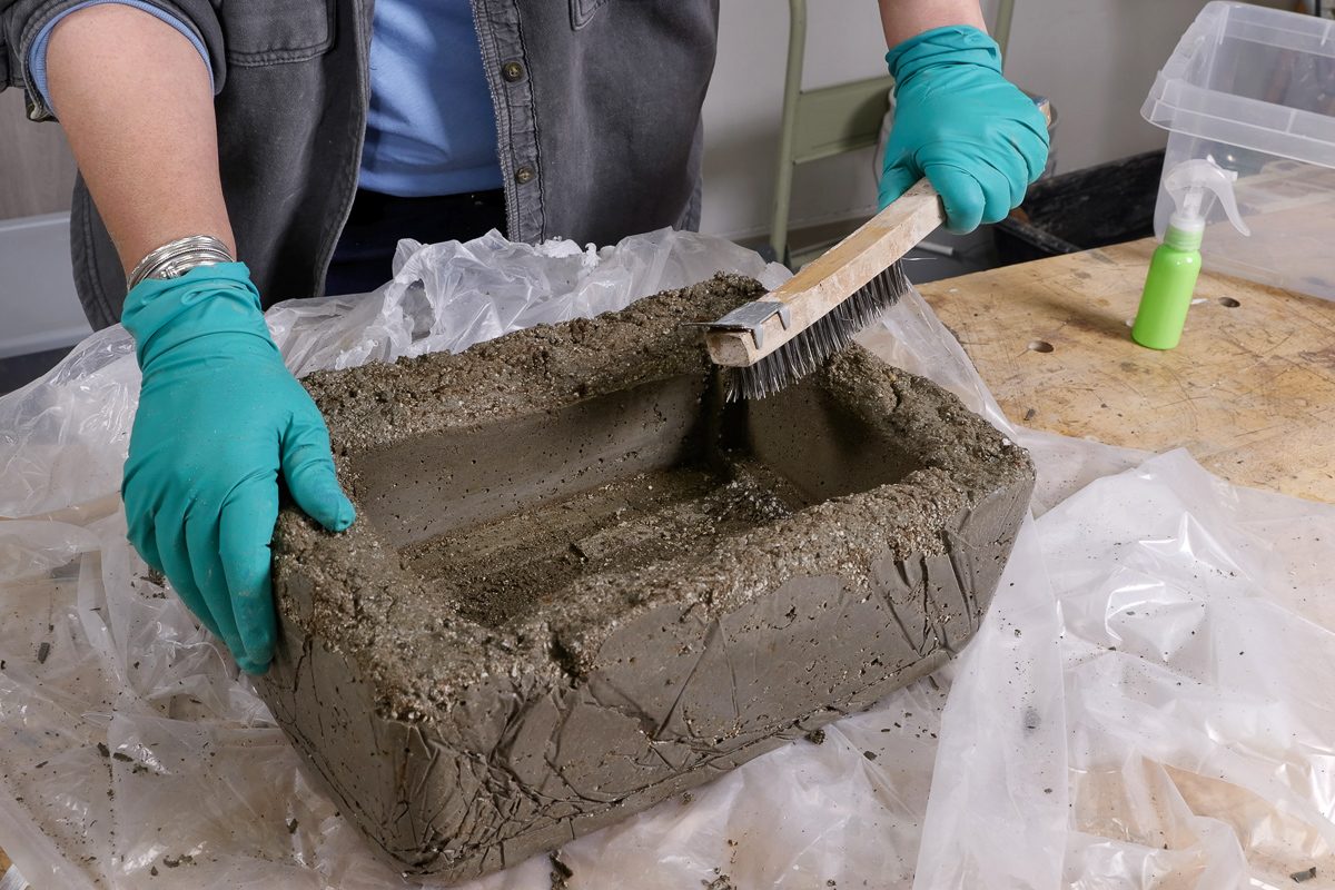 de-molding the cured mixture and using wire brush to remove loose bits of material