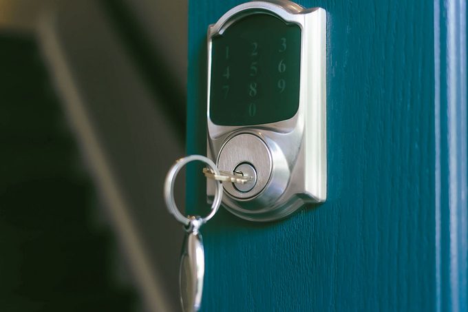 Close-up of house key in lock of open front door